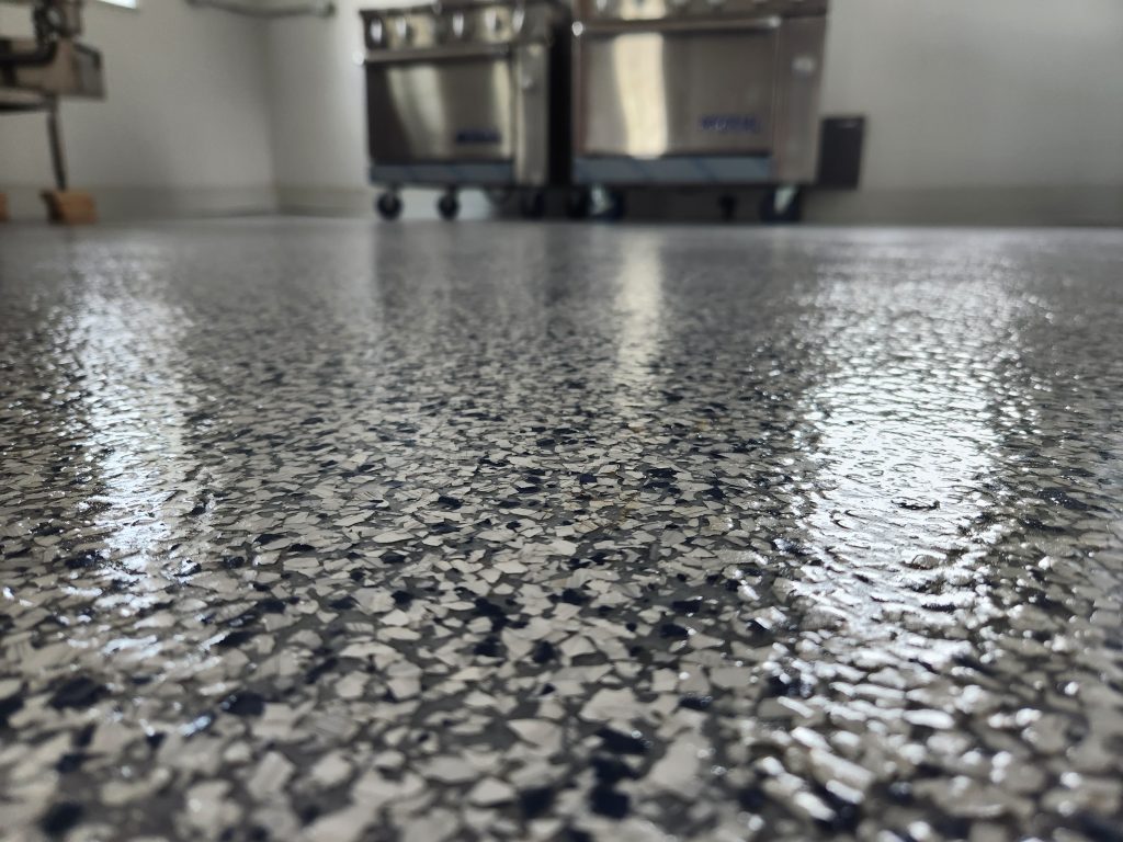 concrete floor with white and black flakes and a high gloss urethane coating for high traffic areas